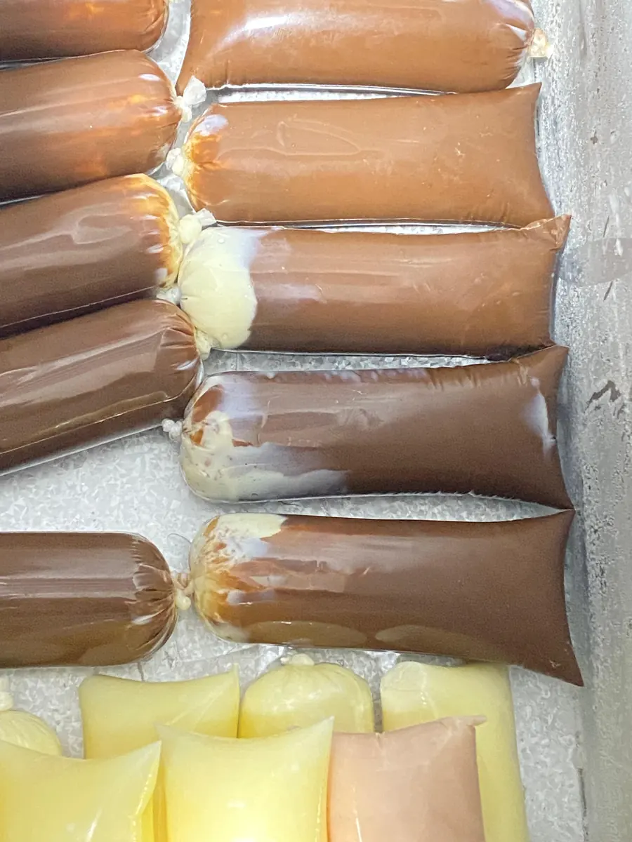 Lote de geladinhos de chocolate com recheio de Ninho alinhados no freezer